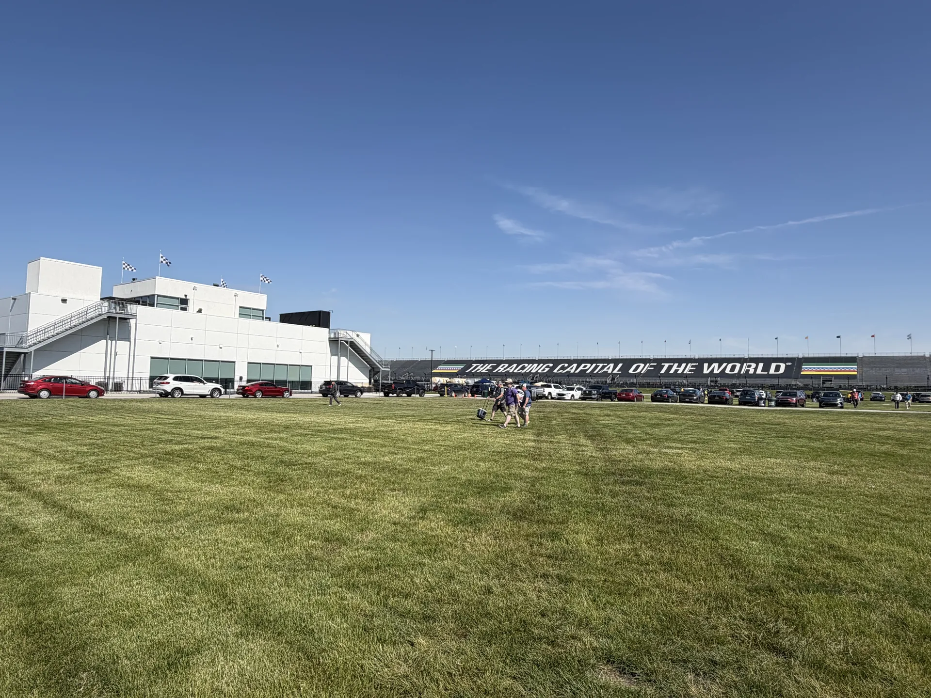 Approaching Indianapolis Motor Speedway with the Racing Capital of the World sign visible across the grandstand