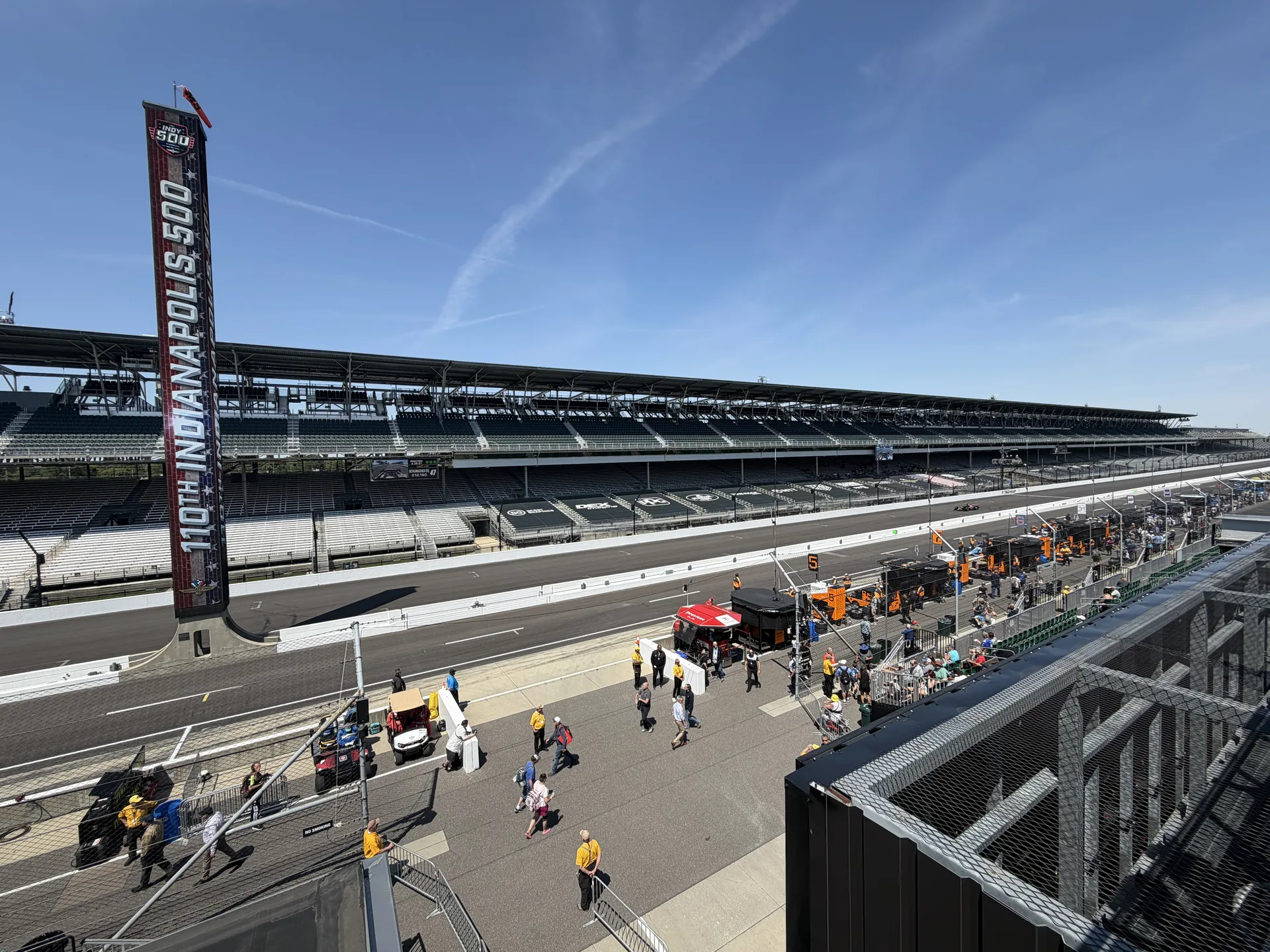 Pit lane and 110th Indianapolis 500 pylon with attendees walking the apron at IMS