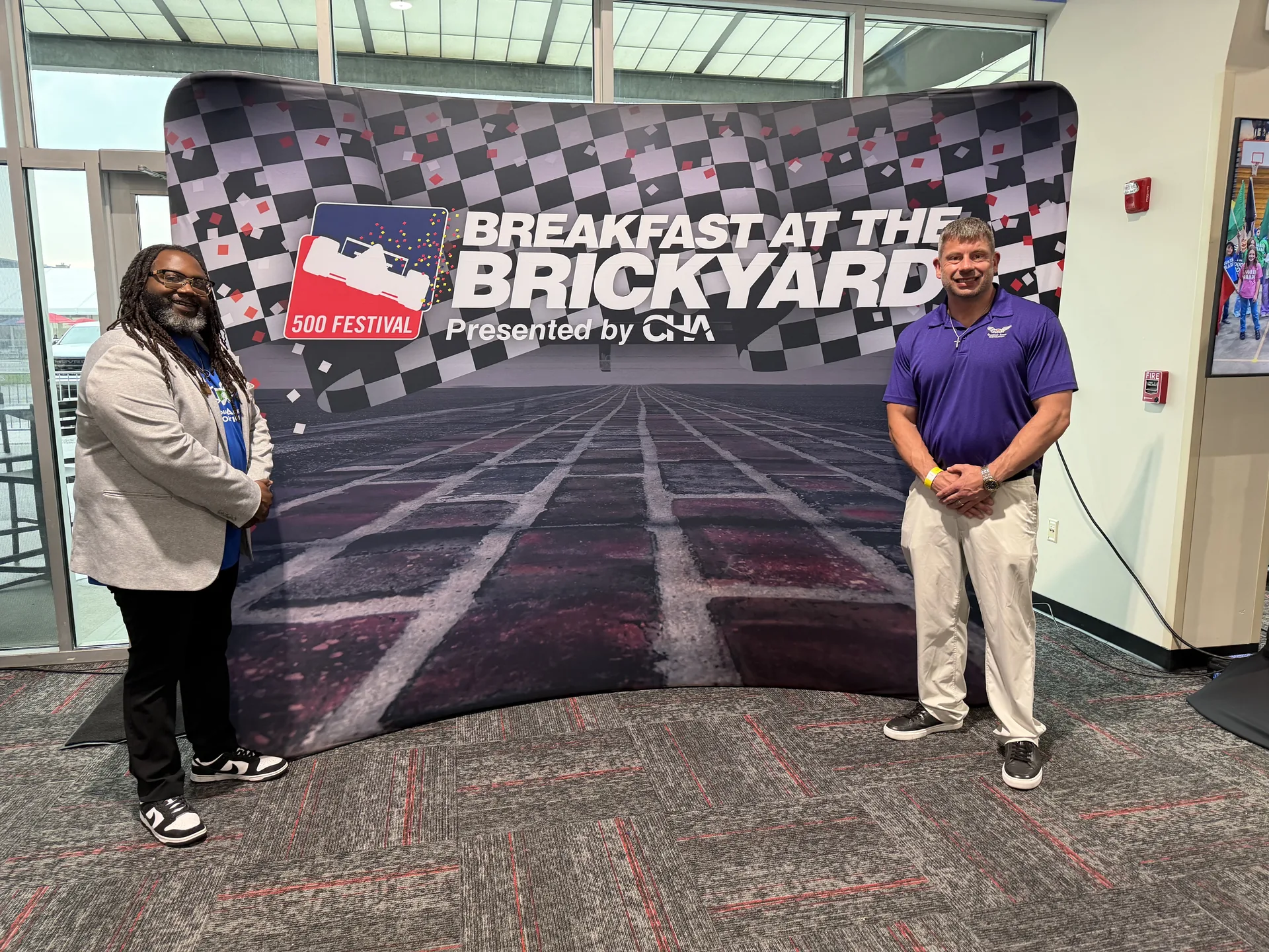 Guardian Angel team posing in front of the Breakfast at the Brickyard backdrop presented by CHA