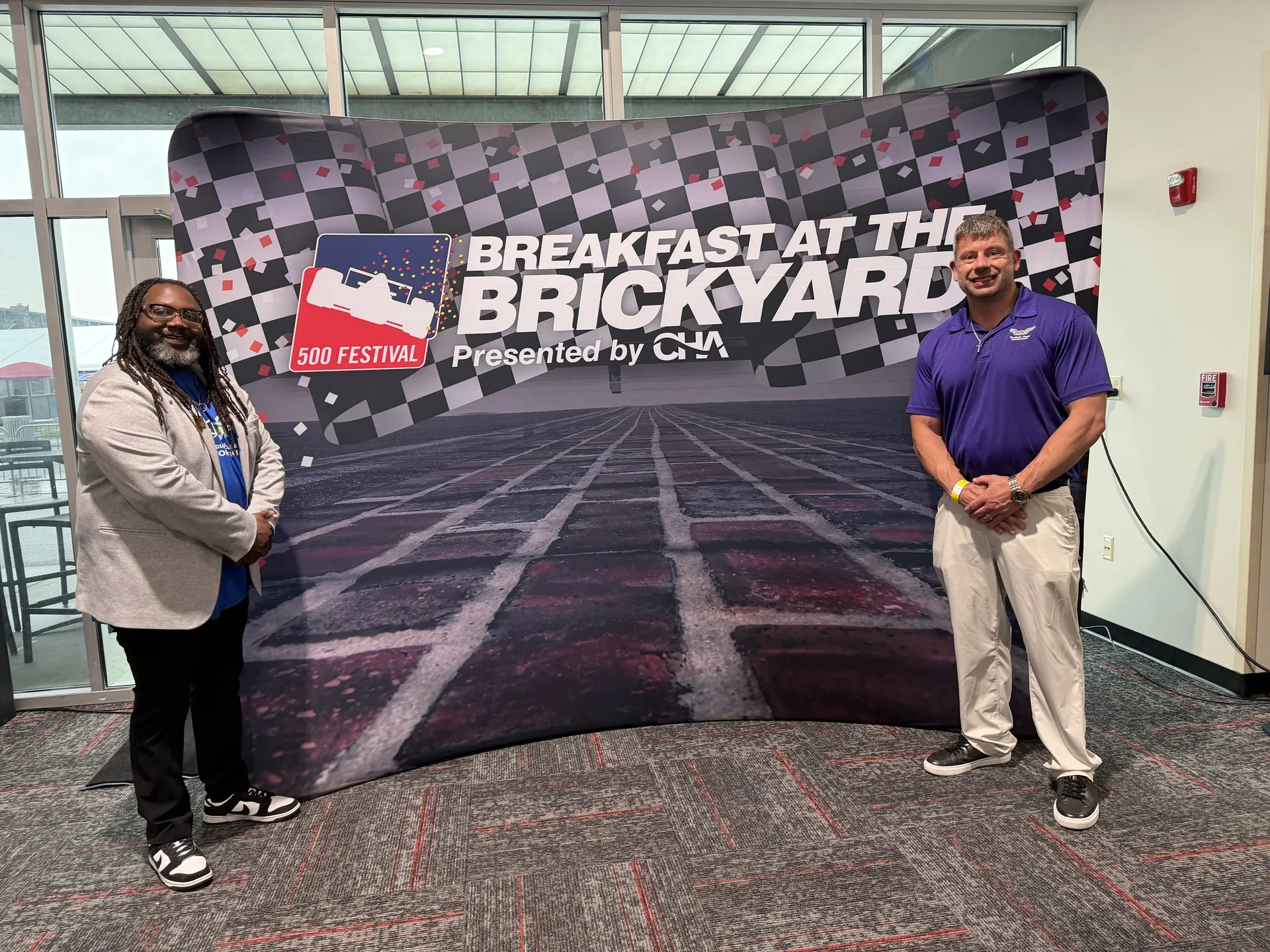 Guardian Angel Restoration team posing wide at the official Breakfast at the Brickyard branded backdrop