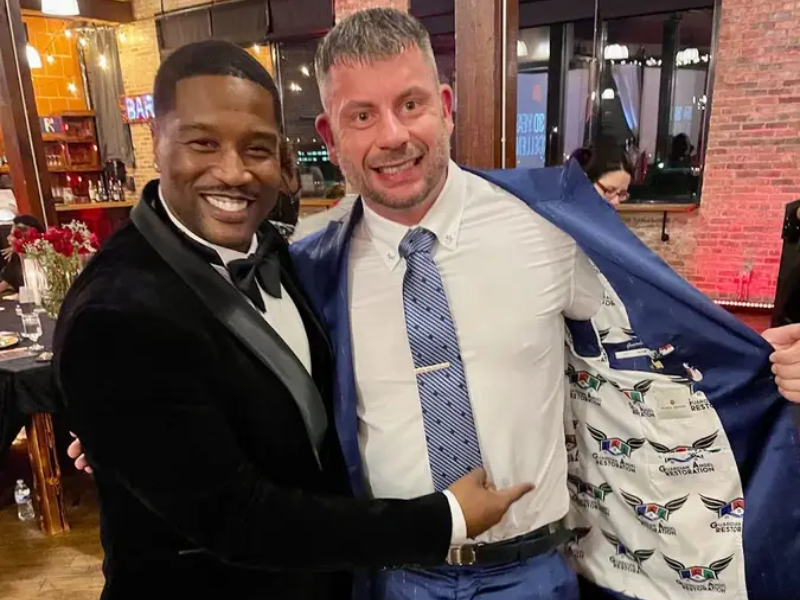 Michael Talbot, Founder of Guardian Angel Restoration, at a community gala in his Guardian Angel branded blazer