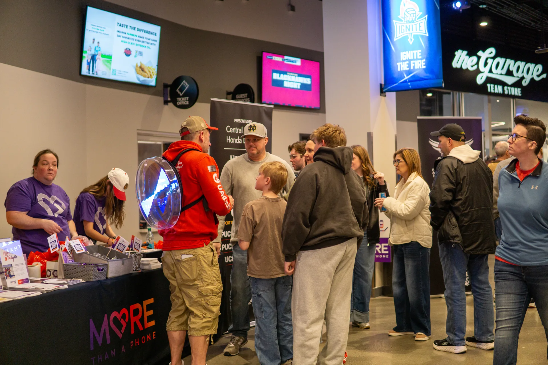 Fans leaning in to receive balloon animals at the Guardian Angel booth
