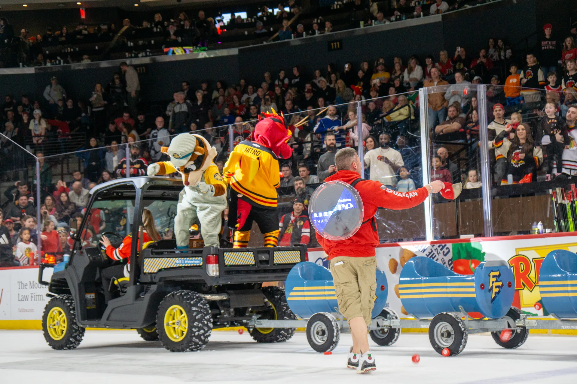 Guardian Angel crew member hugs a little girl in a blue dress at the Indy Fuel game