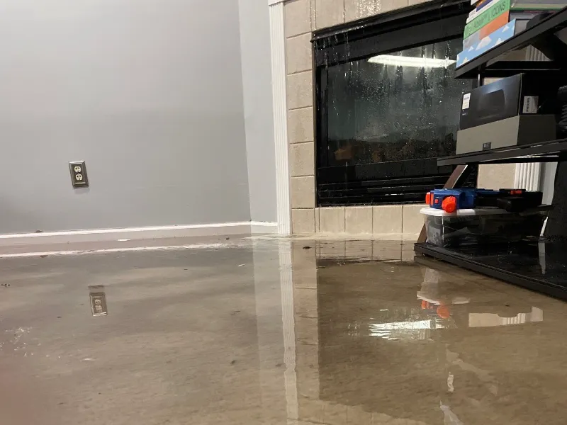 Flooded basement with standing water covering finished flooring and children's belongings &mdash; the kind of emergency Guardian Angel Restoration responds to across Indianapolis, IN