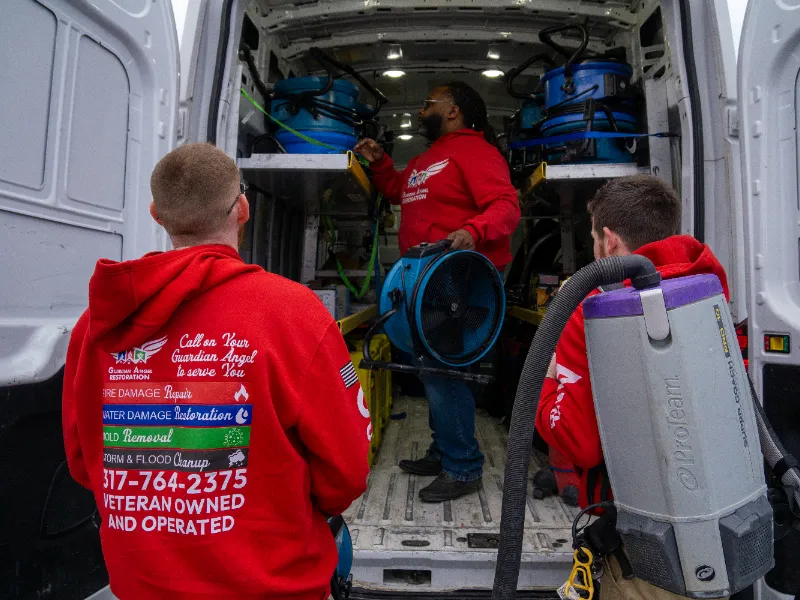 Guardian Angel Restoration crew loading commercial water mitigation equipment into a service van for a Fishers Indiana emergency dispatch