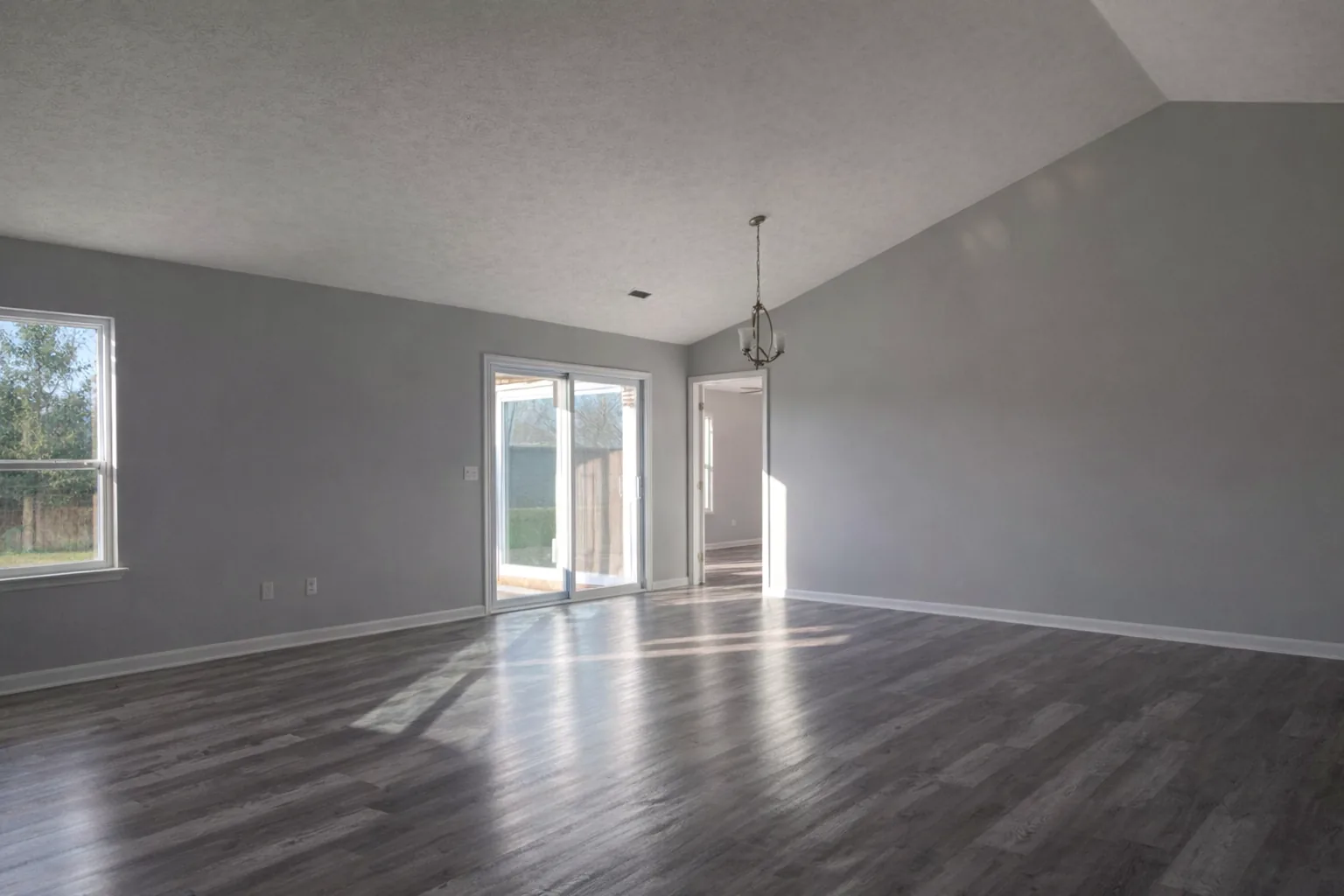 Rebuilt living room with fresh gray paint, new trim and ceiling after fire restoration.