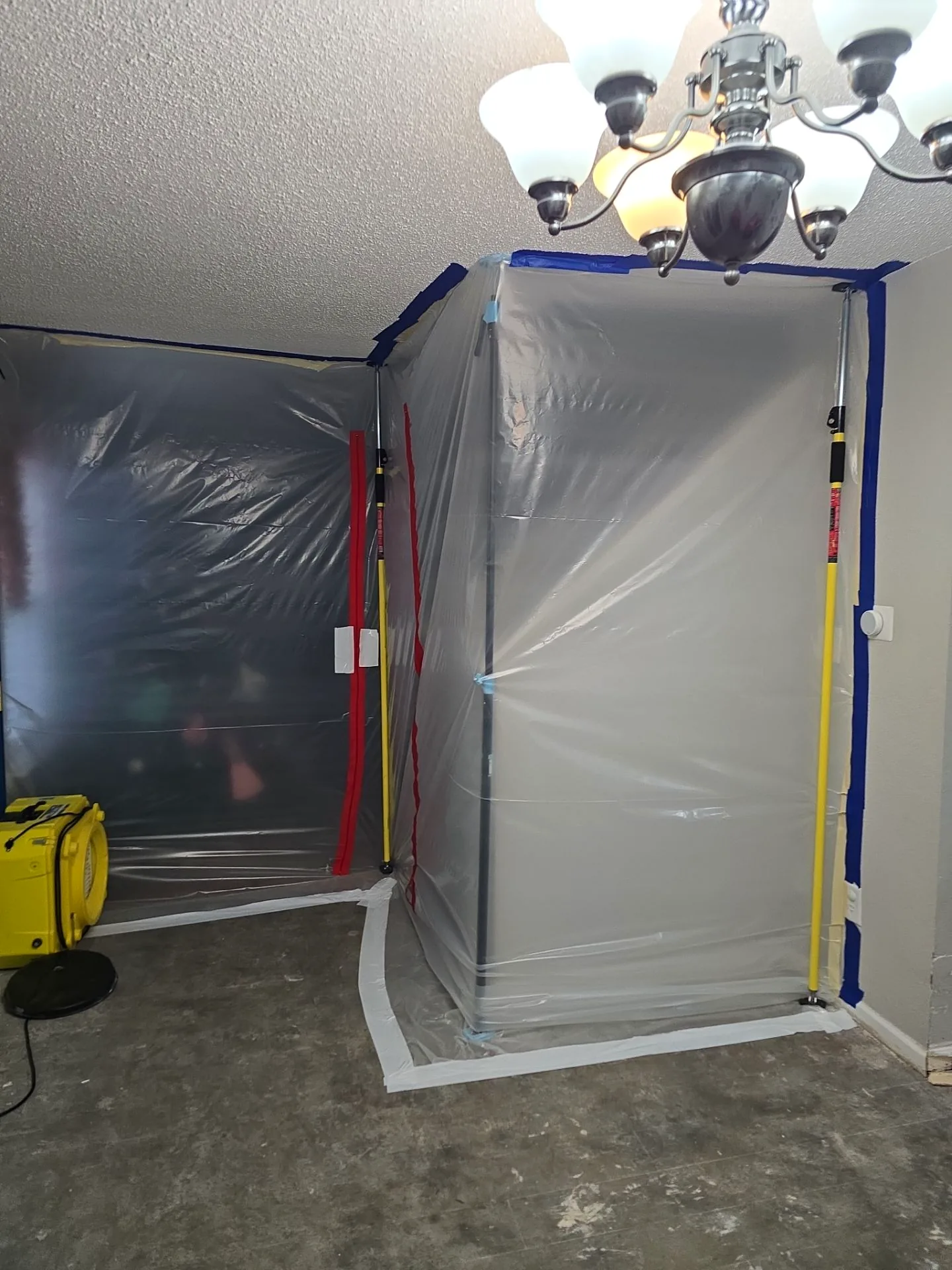 Sealed containment with plastic sheeting, zipper entry and an air scrubber isolating the mold work area.