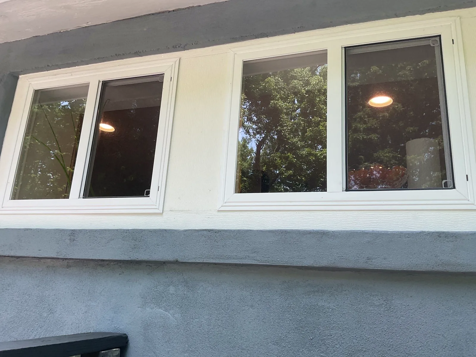 New white windows installed on the rebuilt exterior wall after storm damage.