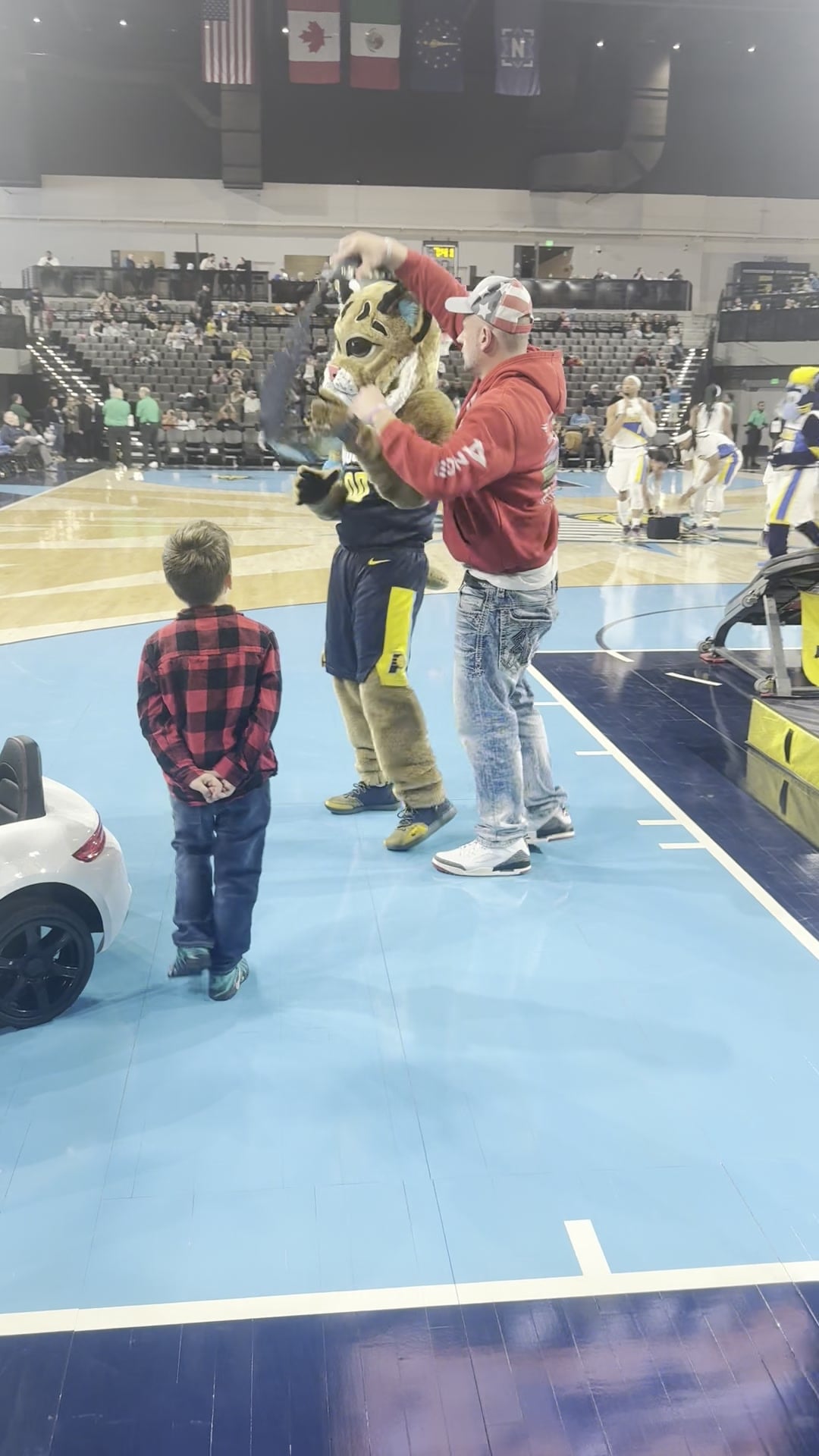 Owner and son on the court with the Boomer mascot at a Noblesville Boom home game